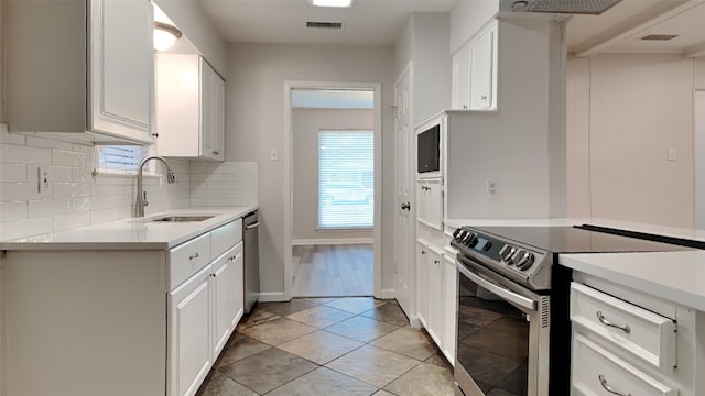 2300 Anders Dr, Mesquite, TX 75150 - kitchen with backsplash, light countertops, visible vents, a sink, and appliances with stainless steel finishes