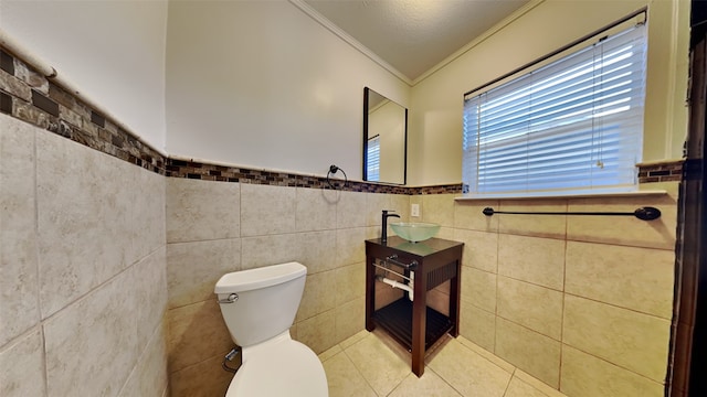 2300 Anders Dr, Mesquite, TX 75150 - half bath featuring crown molding, wainscoting, tile walls, toilet, and tile patterned flooring