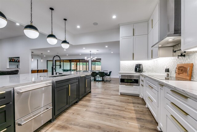 kitchen with wall chimney exhaust hood, white cabinets, visible vents, decorative backsplash, and appliances with stainless steel finishes