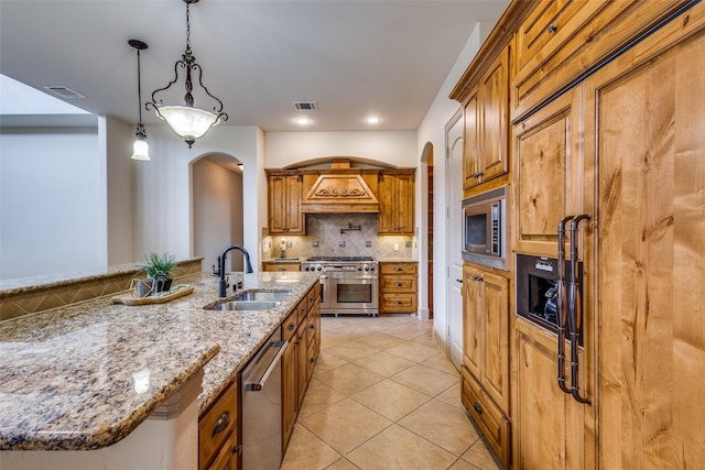4312 Blue Quail Dr, Mckinney, TX 75072 - kitchen featuring a sink, stainless steel appliances, arched walkways, backsplash, and light tile patterned flooring