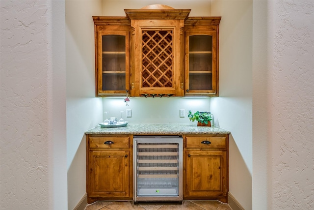 4312 Blue Quail Dr, Mckinney, TX 75072 - indoor dry bar with beverage cooler, baseboards, light tile patterned floors, and a textured wall