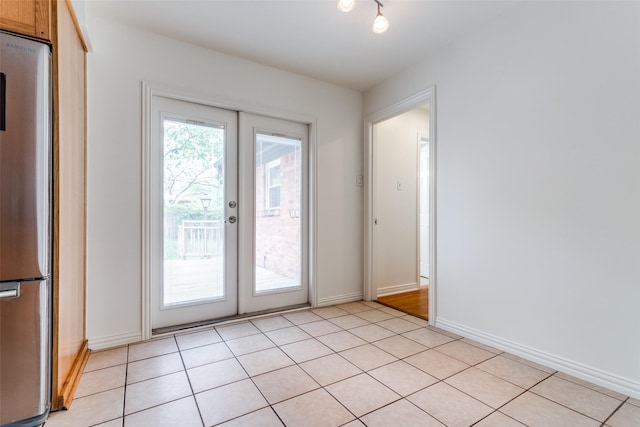 doorway with baseboards and french doors