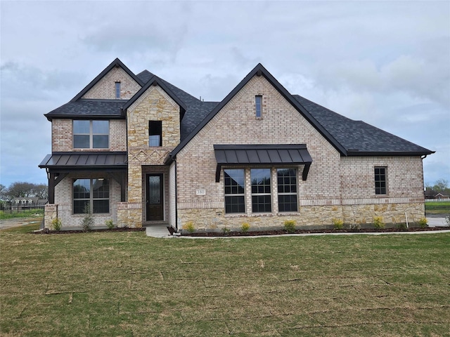 view of front of house with brick siding, a front lawn, and a standing seam roof