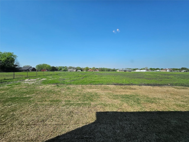 view of yard featuring a rural view and fence