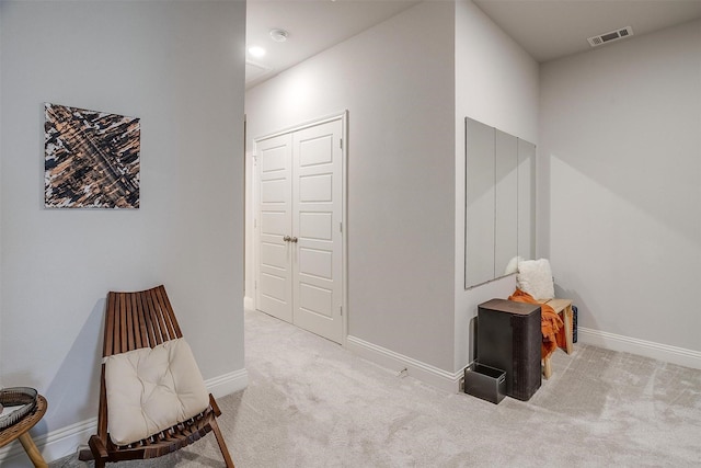 living area featuring carpet floors, visible vents, and baseboards