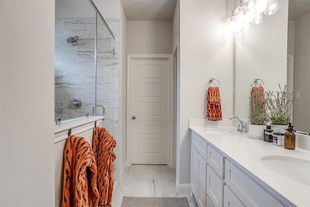 bathroom featuring double vanity, marble finish floor, a stall shower, and a sink