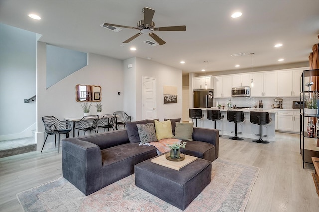 living room featuring recessed lighting, visible vents, light wood finished floors, and ceiling fan