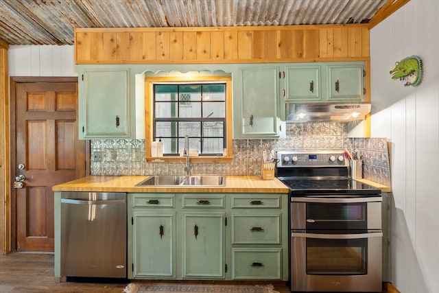 230 W Sesame St, Karnack, TX 75661 - kitchen with stainless steel appliances, under cabinet range hood, green cabinetry, a sink, and tasteful backsplash