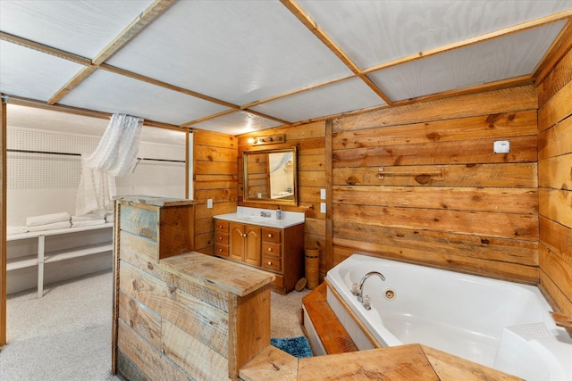 230 W Sesame St, Karnack, TX 75661 - bathroom featuring a whirlpool tub, vanity, and wooden walls