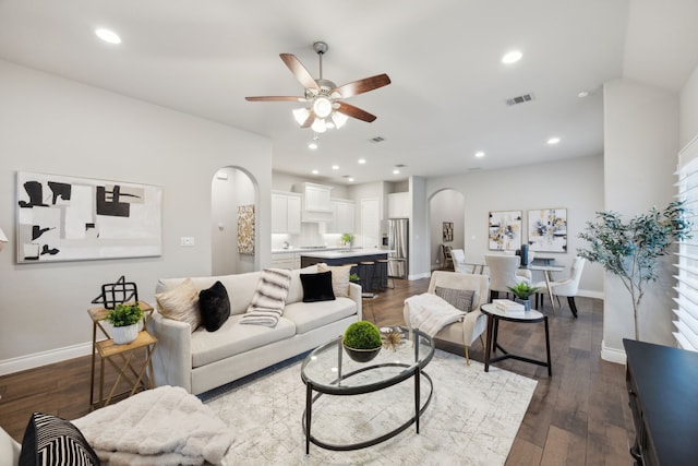 8517 Holliday Creek Way, Mckinney, TX 75071 - living room with arched walkways, a ceiling fan, baseboards, dark wood finished floors, and recessed lighting