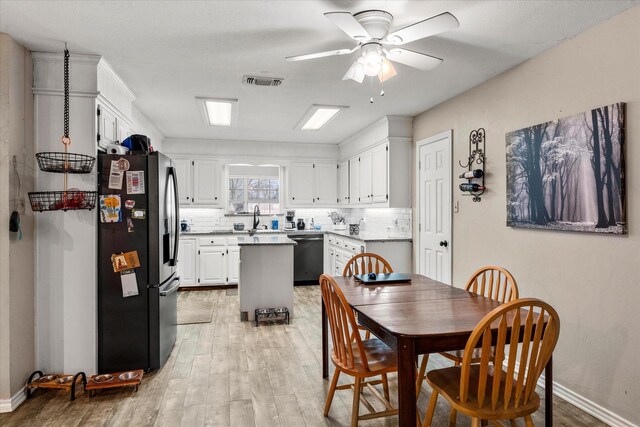dining area with light wood-style floors, visible vents, a ceiling fan, and baseboards