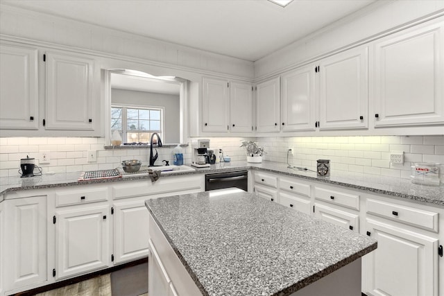 kitchen with white cabinets, backsplash, and dishwashing machine