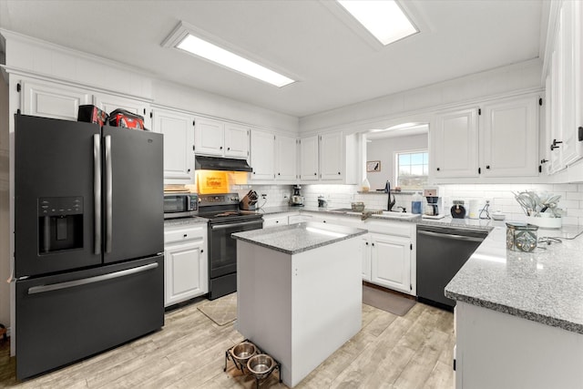 kitchen with stainless steel appliances, backsplash, white cabinetry, light stone countertops, and under cabinet range hood
