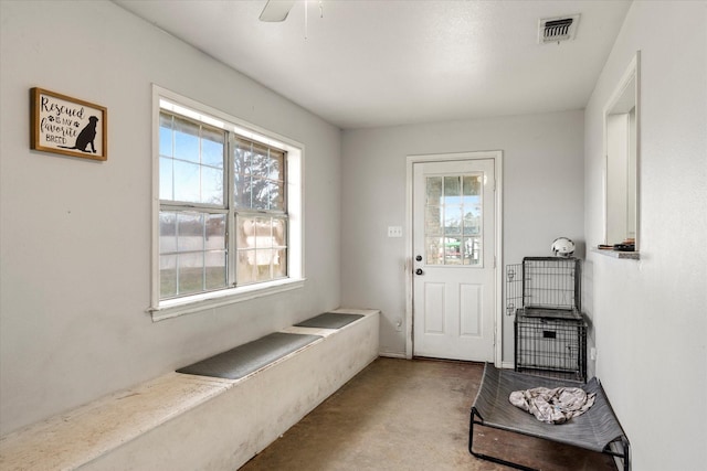 doorway to outside featuring concrete floors, plenty of natural light, visible vents, and ceiling fan
