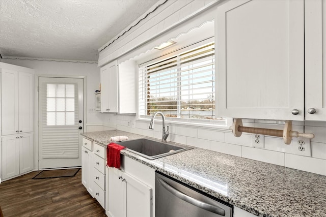 kitchen featuring decorative backsplash, dishwasher, a sink, and a textured ceiling