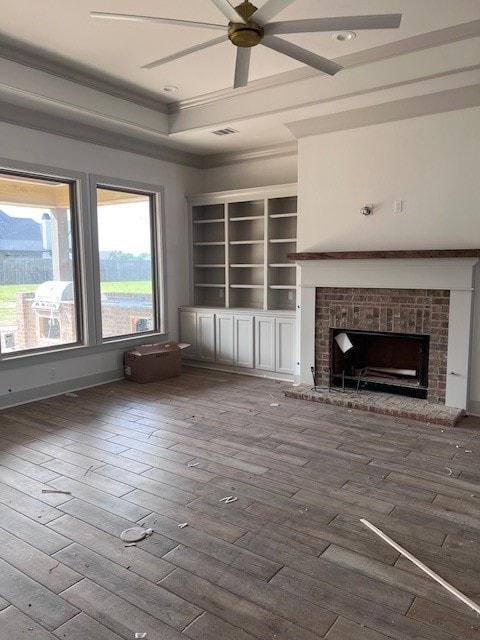 unfurnished living room with a brick fireplace, a ceiling fan, hardwood / wood-style flooring, and ornamental molding