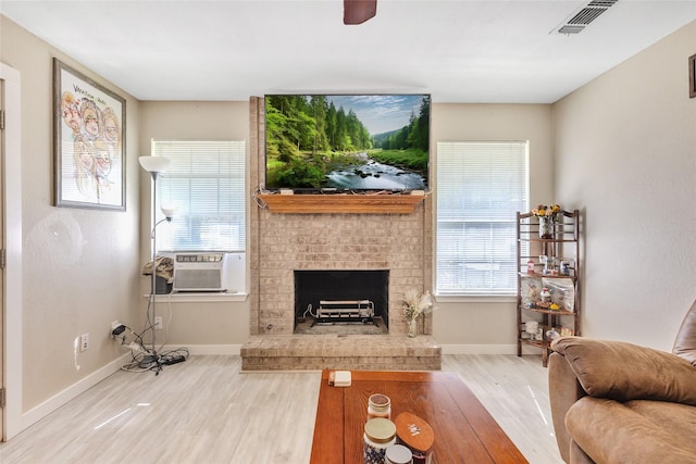 103 Elm St, Roxton, TX 75477 - living area featuring wood finished floors, visible vents, baseboards, cooling unit, and a fireplace