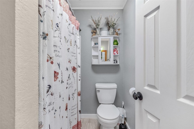 103 Elm St, Roxton, TX 75477 - bathroom featuring curtained shower, toilet, and baseboards