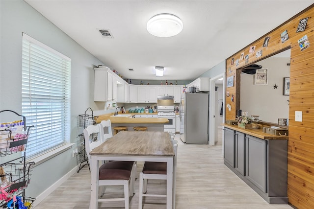 103 Elm St, Roxton, TX 75477 - kitchen featuring white gas range, a sink, under cabinet range hood, visible vents, and freestanding refrigerator