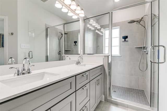 full bathroom with a sink, a shower stall, and double vanity