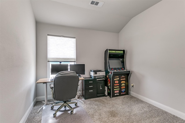 office area with baseboards, vaulted ceiling, visible vents, and light colored carpet