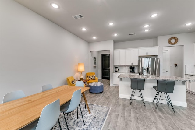 dining room with recessed lighting, light wood-style floors, visible vents, and baseboards