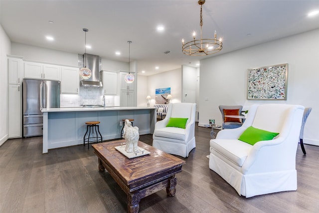 living area with an inviting chandelier, dark wood-style floors, and recessed lighting