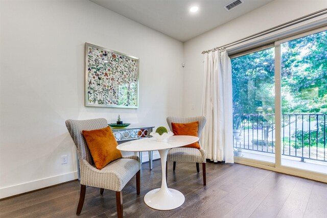 sitting room with plenty of natural light, visible vents, baseboards, and wood finished floors