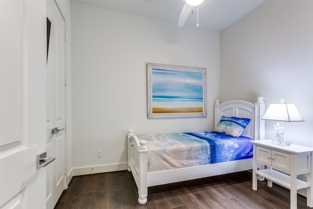 bedroom featuring baseboards and dark wood-style flooring