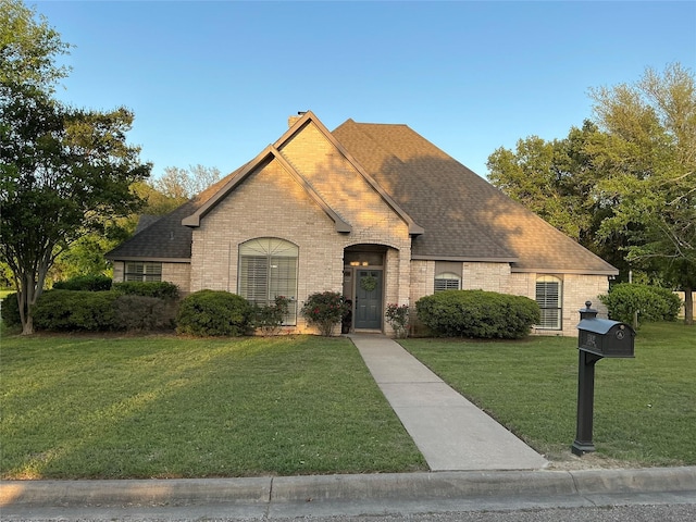1302 Summit Dr, Mexia, TX 76667 - french country home with a front lawn, roof with shingles, a chimney, and brick siding