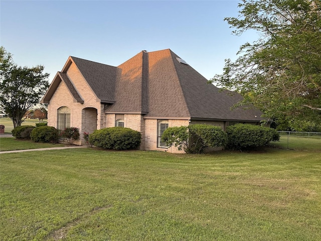1302 Summit Dr, Mexia, TX 76667 - view of front of house featuring fence, a front lawn, roof with shingles, and brick siding
