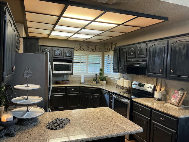 1302 Summit Dr, Mexia, TX 76667 - kitchen featuring dark cabinetry, ventilation hood, a sink, and appliances with stainless steel finishes