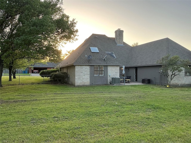 1302 Summit Dr, Mexia, TX 76667 - rear view of house featuring a lawn, a chimney, roof with shingles, and a patio
