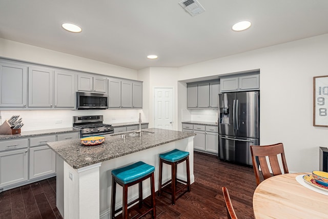 4409 Switchgrass St, Celina, TX 75009 - kitchen with stainless steel appliances, a sink, visible vents, gray cabinetry, and dark wood-type flooring