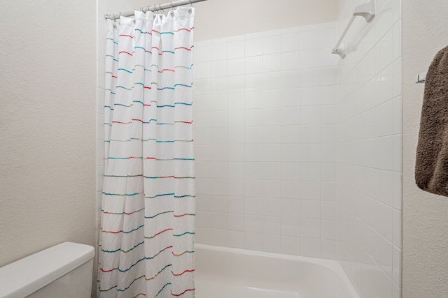 4409 Switchgrass St, Celina, TX 75009 - bathroom featuring a textured wall, shower / bath combo with shower curtain, and toilet