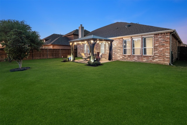 4409 Switchgrass St, Celina, TX 75009 - rear view of property featuring a gazebo, brick siding, a patio, and a fenced backyard