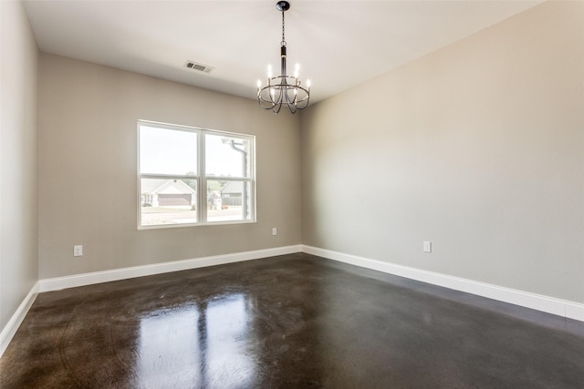 spare room featuring finished concrete flooring, baseboards, visible vents, and a chandelier