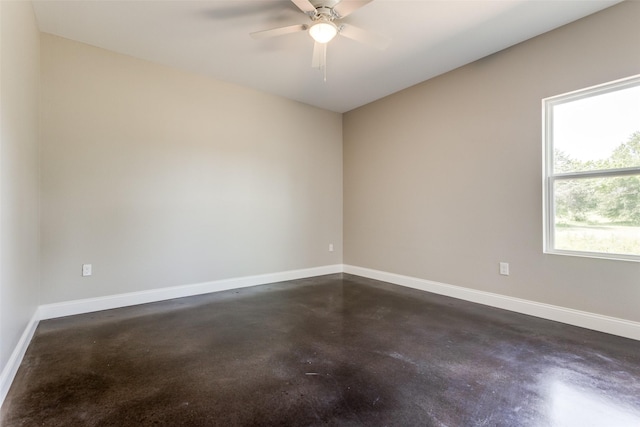 unfurnished room with baseboards, ceiling fan, and concrete floors
