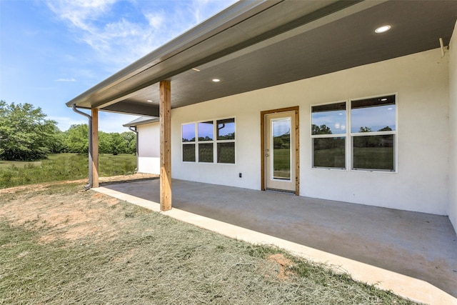 rear view of house with a patio area and stucco siding