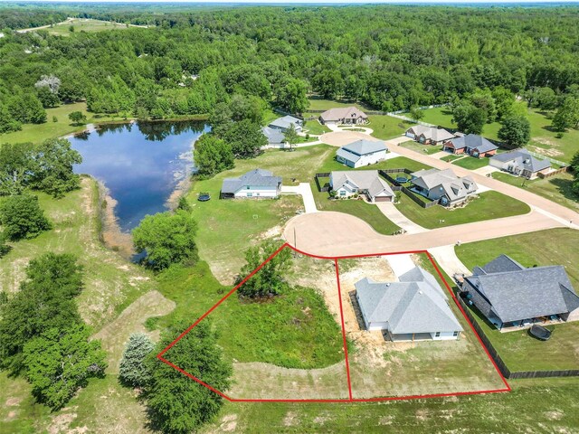 birds eye view of property featuring a forest view, a residential view, and a water view