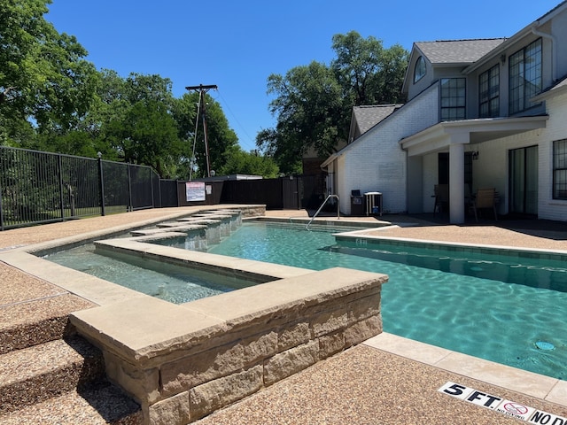 pool with a patio, a fenced backyard, and an outdoor hot tub
