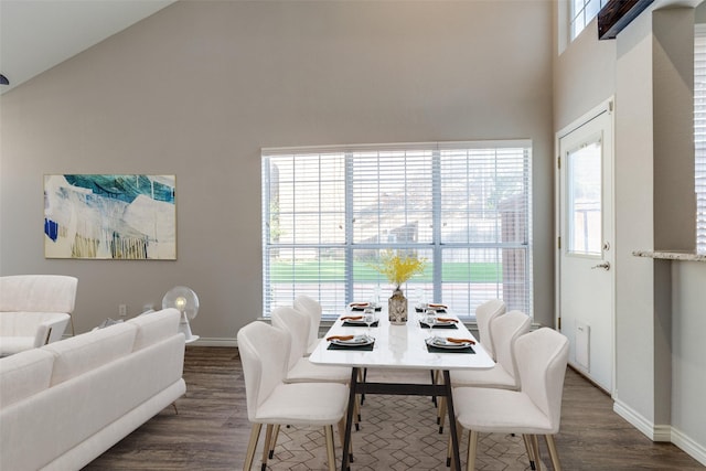dining area with baseboards, dark wood finished floors, and a towering ceiling