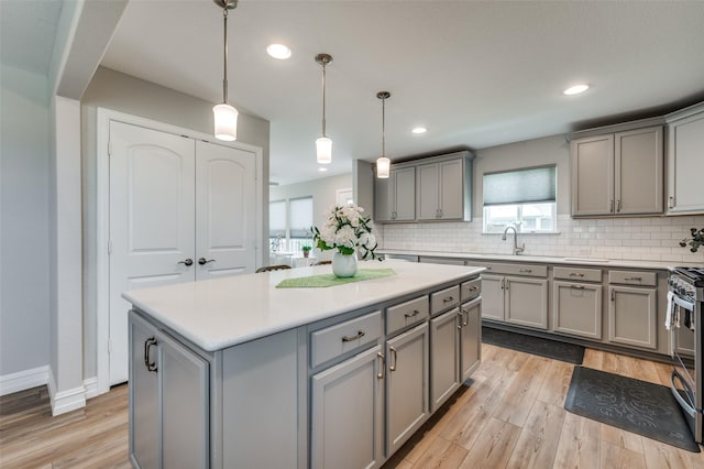 1232 Bright Stars Dr, Little Elm, TX 76227 - kitchen with backsplash, light countertops, light wood-type flooring, and gray cabinets