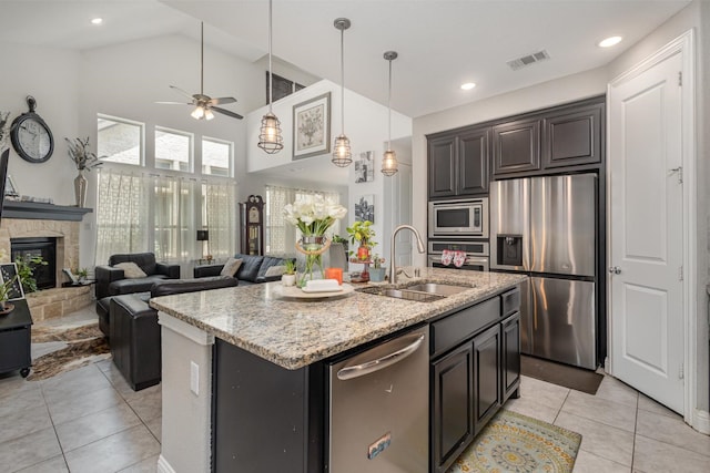 kitchen featuring appliances with stainless steel finishes, a sink, a ceiling fan, light tile patterned floors, and visible vents