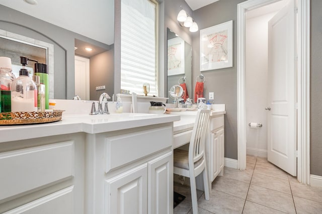 bathroom with vanity, baseboards, and tile patterned flooring