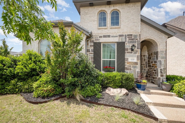 entrance to property featuring brick siding and stone siding