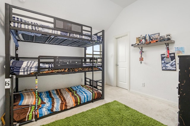 bedroom featuring baseboards, lofted ceiling, and carpet