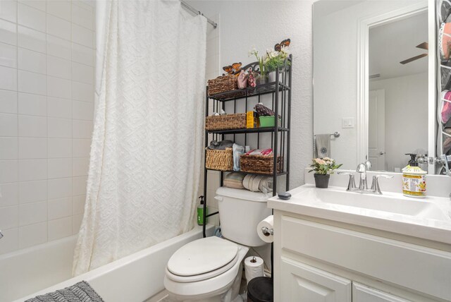 full bath featuring vanity, toilet, a textured wall, and shower / tub combo
