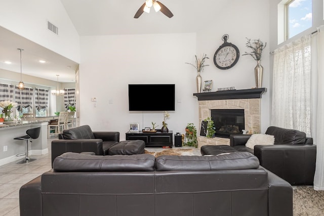 living area with visible vents, tile patterned flooring, a fireplace, high vaulted ceiling, and a ceiling fan