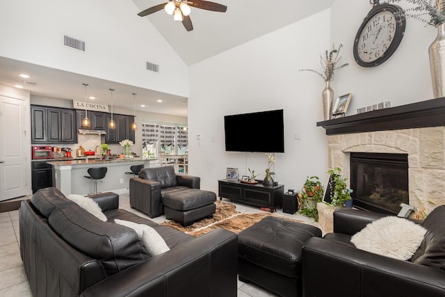 living area with visible vents, ceiling fan, light tile patterned floors, and high vaulted ceiling